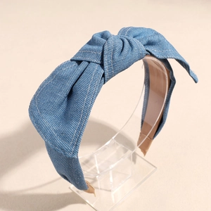 Close-up of denim blue knotted headband with white decorative stitching and non-slip lining