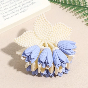 Detailed close-up of a lily of the valley hair claw clip with matte purple tulip buds