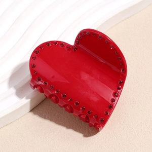 Vue détaillée de la pince à cheveux cœur rouge avec strass brillants et texture résine