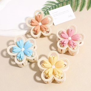 Matte flower hair claws in four colors shown on a white tray with elegant decor