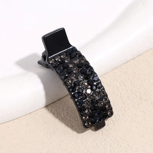 Close-up of black duckbill hair clip encrusted with dark grey sparkling rhinestones
