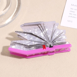 Macro shot of creative book-shaped hair claw clip with pearlescent finish and red bookmark