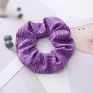 Detailed close-up of purple knit bow hair clip with textured waffle fabric detail