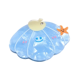 Light blue shell hair claw clip with smiling face and orange starfish charm ornament