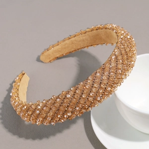 Détail du serre-tête en strass dorés champagne avec broderie de perles de luxe