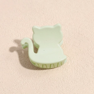 Detail of light green cat-shaped hair claw clip made of smooth acrylic resin material