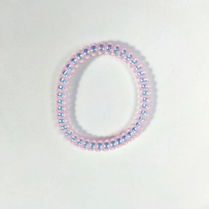 Gros plan sur élastique spirale rose dégradé avec effet laser perlé sur fond blanc