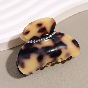 Close-up of tortoise shell acetate hair claw clip with inlaid sparkling rhinestones
