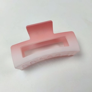 Détail de la pince à cheveux dégradé rose mat avec design rectangulaire ajouré pour femmes