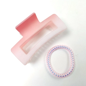 Détail d'une pince à cheveux mate dégradé rose et élastique spirale brillant