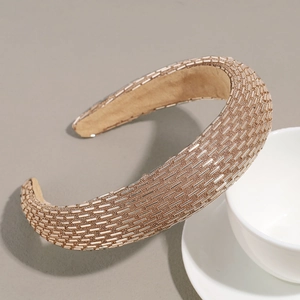 Detailed macro view of champagne gold tubular beads on a padded baroque style headband