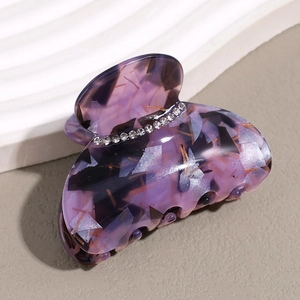 Detail view of purple acetate hair claw with marble texture and rhinestone inlay