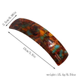 Detail of tortoise shell acetate hair clip with blue accents and gold spring fastener