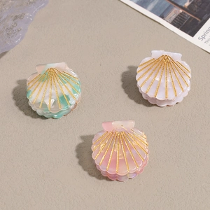 Three-piece mini acetate shell hair claws with marble textures and gold glitter accents