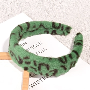 Detailaufnahme von grünem Plüsch-Haarreif mit Leopardenmuster und Kunstfell-Textur