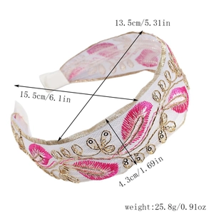 Close-up of pink leaf embroidery and golden sequins on the wide fabric headband