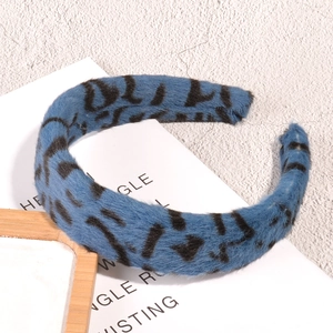 Nahaufnahme des weichen blauen Plüsch-Haarreifens mit Leopardenmuster und gepolsterter Textur