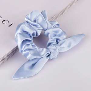 Detailaufnahme eines hellblauen Satin-Haargummis mit einem modischen Knotendesign