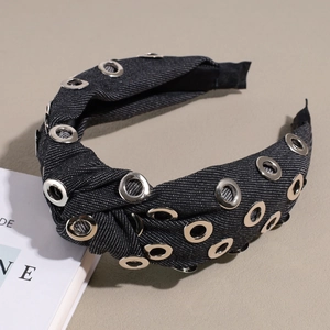 Détail du serre-tête noué en denim gris avec œillets métalliques argentés et design
