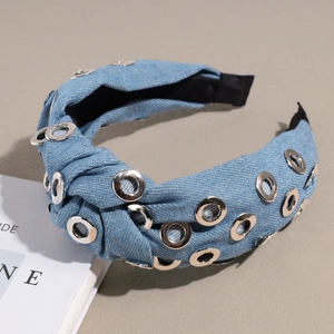 Gros plan du serre-tête noué en jean avec œillets métalliques et texture denim délavé