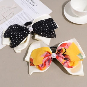 Detail of elegant bow banana hair clips with polka dots, floral prints and pearl accents