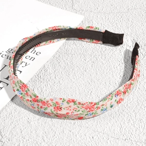 Détail montrant les dents antidérapantes et le tissu floral rose du serre-tête noué