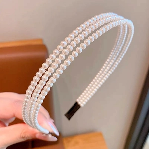 Vue détaillée du serre-tête à trois rangées de perles blanches avec embouts noirs de protection
