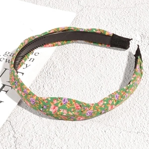 Détail d'un serre-tête floral vert à nœud avec dents antidérapantes et embout doux