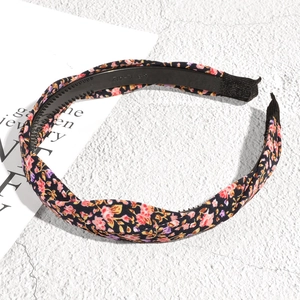 Détail d'un serre-tête en tissu floral avec nœud torsadé et dents antidérapantes