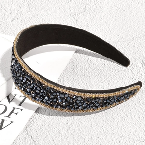 Detailed view of luxury wide headband with dark crystals and golden bead edges