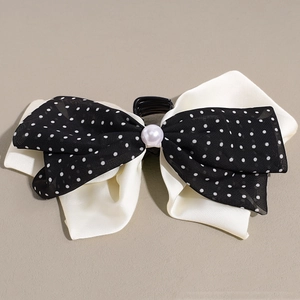 Detail of a French vintage bow hair claw with satin, polka dot mesh, and a central pearl