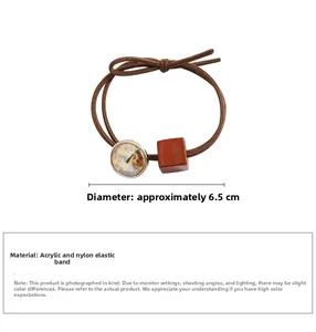 Close-up of brown elastic hair tie with amber crystal and cubic acrylic bead detail