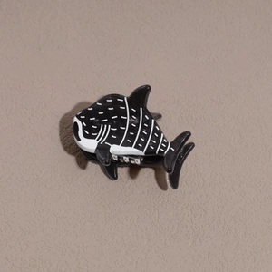 Détail de la mini pince à cheveux requin-baleine en acétate avec motif noir et blanc