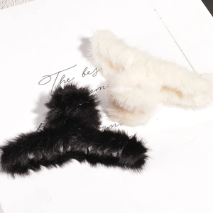 Détails de la texture pelucheuse des grandes pinces à cheveux noires et beige