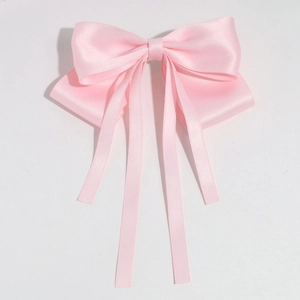 Gros plan sur le nœud papillon en satin rose clair avec rubans élégants et texture soyeuse