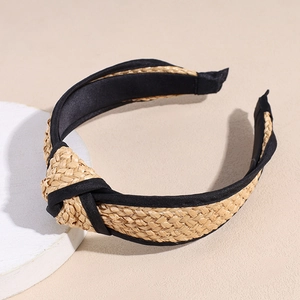 Detailed macro view of woven raffia headband with natural straw texture and top knot design