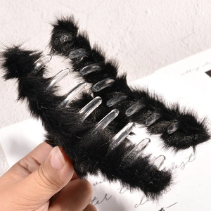 Détail de la texture en fausse fourrure noire sur une grande pince à cheveux pour l'hiver