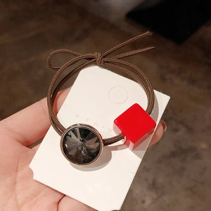 Detail of Korean style elastic hair tie with red square crystal and black round charm