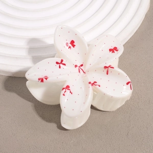 Pince à cheveux fleur avec motifs cerises et nœuds blanc crème sur fond épuré