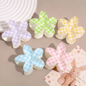 Floral checkered hair claws in five candy colors on a warm neutral background