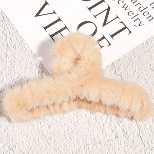 Gros plan sur une grande pince à cheveux en peluche avec fausse fourrure beige