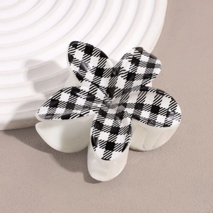 Detailed view of flower hair claw clip with black and white checkerboard pattern texture