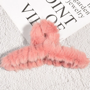 Détail de la pince à cheveux en fausse fourrure rose douce avec texture pelucheuse