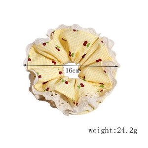 Detail showing a 16cm diameter yellow plaid cherry scrunchie with lace edge and 24.2g weight