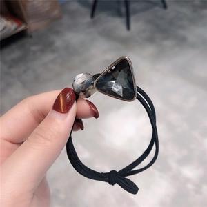 Detail of high-elasticity hair tie featuring a large grey crystal and clear bead accent