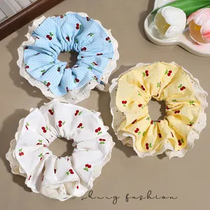 Close-up of three sweet cherry lace hair scrunchies in plaid and white cotton fabric
