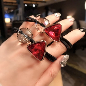 Close-up of dual-use hair ties with red triangular rhinestones and black elastic bands
