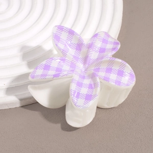 Detail of flower hair claw clip with purple houndstooth pattern on white petals