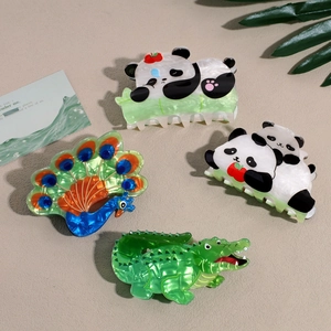 Vue détaillée des pinces à cheveux en acrylique aux motifs de panda et de paon