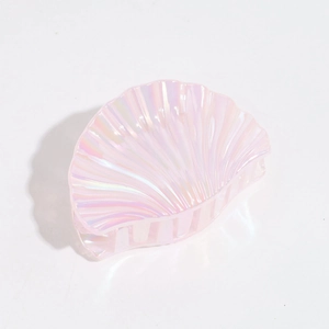 Macro detail of iridescent pink shell hair claw with glossy pearl finish for hair styling